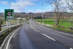 UK highway with green fields, trees and signage pointing to Kilmarnock, Law and Brownlee